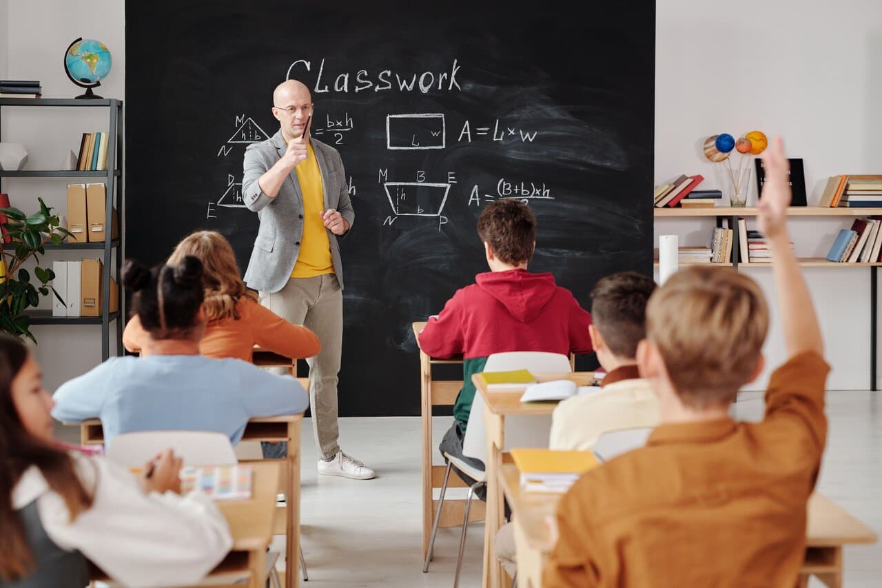 Professor conduzindo aula com alunos em sala de aula moderna