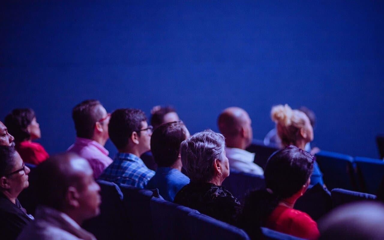 Público sentado em venue de apresentação ao vivo