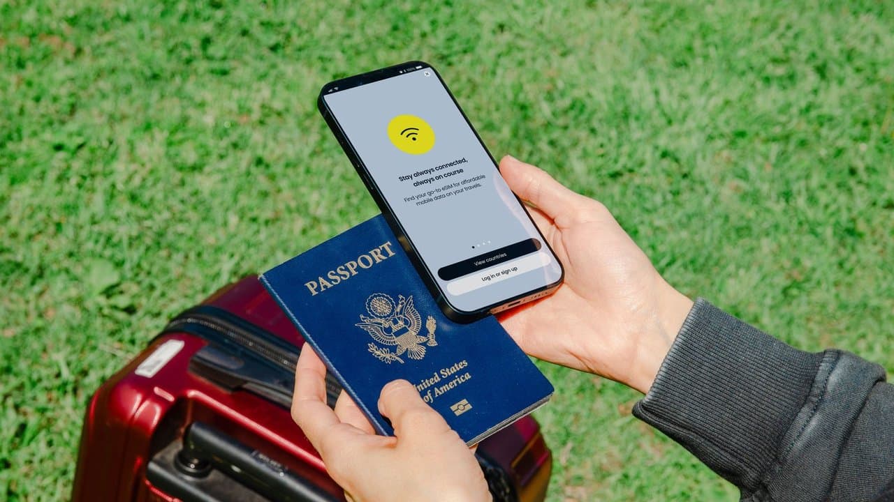 Pessoa segurando passaporte e smartphone