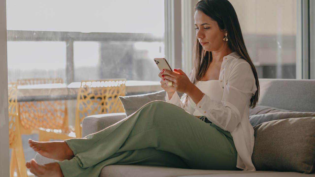 Woman sitting and using her smartphone in an urban setting